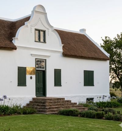 A pristine Cape Dutch style thatched roof home showcasing straight, clean-combed ridge lines and durable structural craftsmanship.